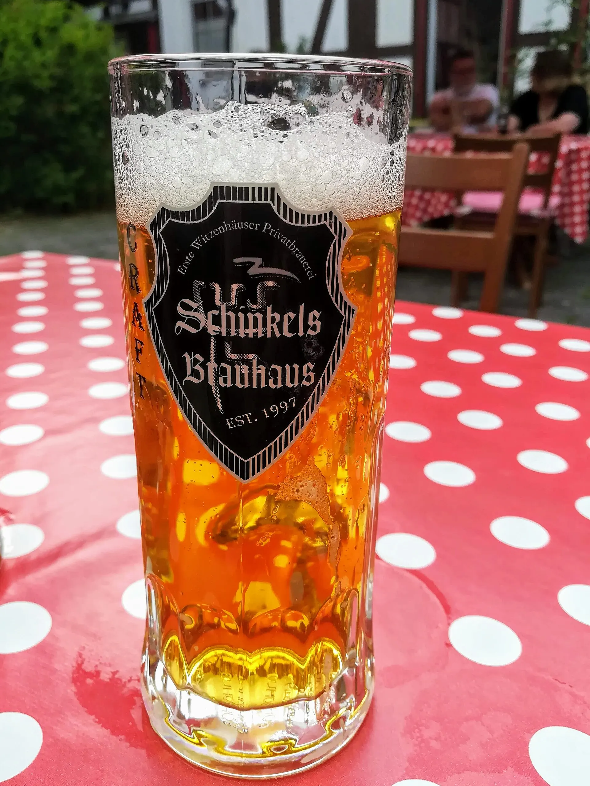 Frisch gezapftes Bier im gebrandeten Brauerei-Glas