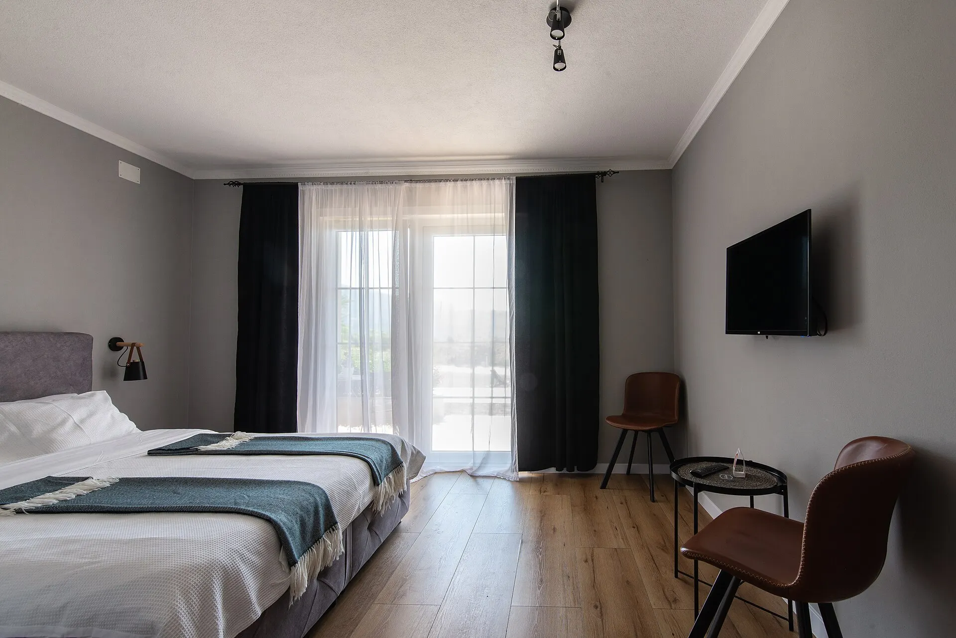 Modernes Hotelzimmer mit bequemem Bett und großem Fenster bei Tageslicht