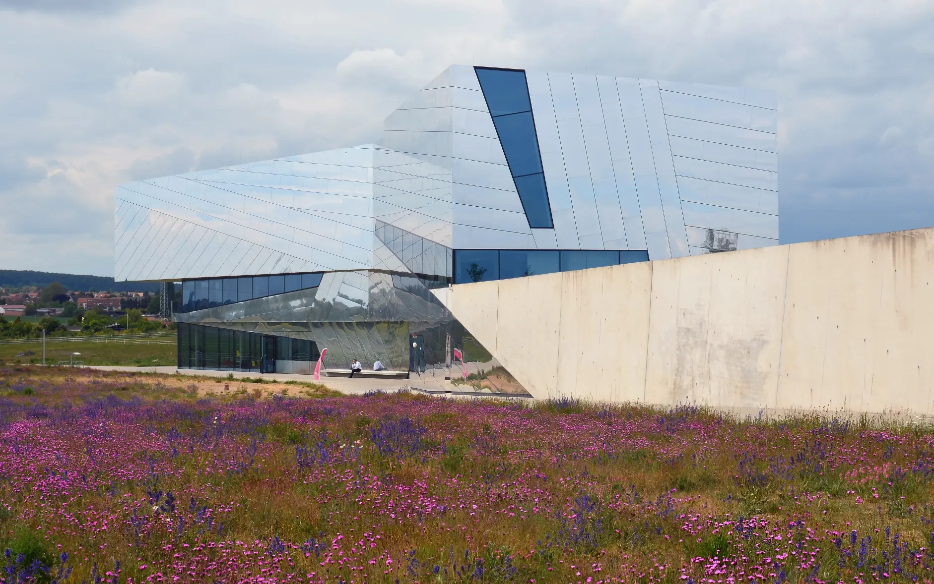 Außenansicht des Forschungsmuseums Schöningen (paläon) mit Blumenwiese im Vordergrund, wo die Schöninger Speere gezeigt werden